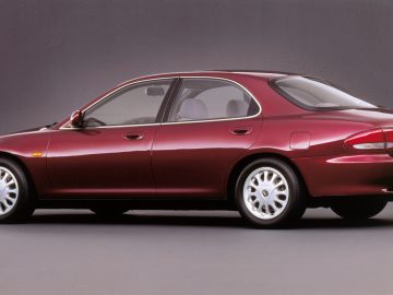 Mazda rode sedan auto weergegeven in profielweergave tegen een grijze achtergrond.
