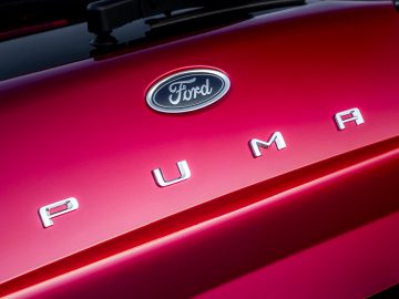 Close-up van het achterembleem van een rode Ford Puma.