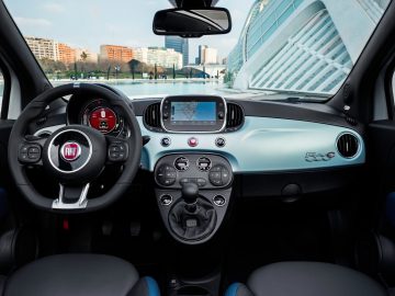 Binnenaanzicht van een Fiat 500 Hybrid met dashboard, stuur en infotainmentsysteem.