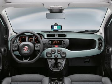 Binnenaanzicht van de Fiat 500 Hybrid met het stuur, het dashboard en de middenconsole met verschillende bedieningselementen en een digitaal display.