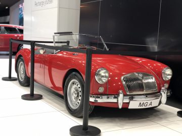 Een klassieke rode MG A-sportwagen tentoongesteld op het Autosalon van Brussel 2020, afgezet met rongen.