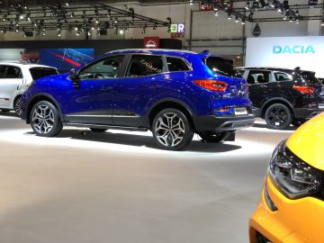 Een blauwe SUV te zien op het Autosalon van Brussel 2020 met andere voertuigen op de achtergrond.