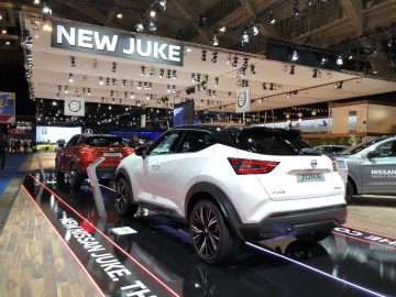Een tentoonstelling van de nieuwe Nissan Juke-modellen op het Autosalon van Brussel 2020 met prominente branding op de achtergrond.