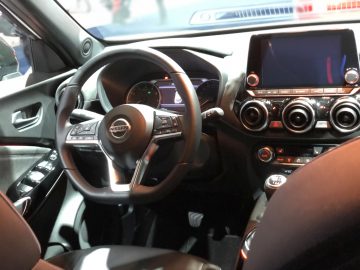Binnenaanzicht van een modern Nissan-voertuig, tentoongesteld op het Autosalon van Brussel 2020, met het stuur, het dashboard en het infotainmentsysteem.