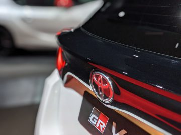 Close-up van een Toyota GR Yaris-badge op een zwart-witte auto.