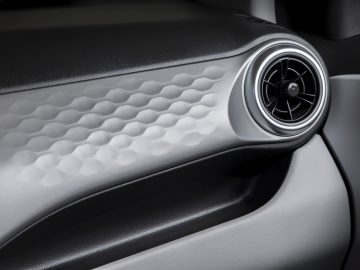Interieur van de Hyundai i10-autodeur met een ronde ventilatieopening en een paneel met textuur.