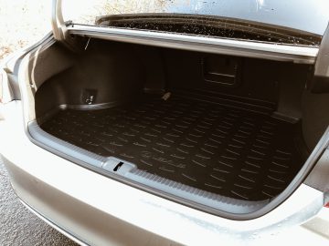 Lege Lexus ES 300h kofferbak met rubberen voering, licht nat van de regen.