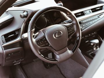 Binnenaanzicht van een Lexus ES 300h-voertuig, met de nadruk op het stuur en het dashboard.