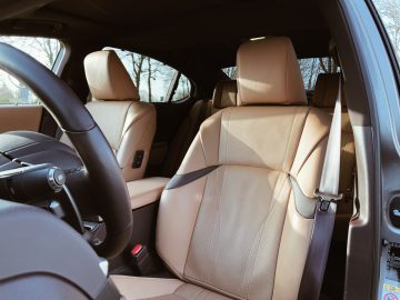 Binnenaanzicht van een Lexus ES 300h met lederen stoelen, stuur en dashboard zichtbaar.