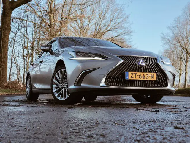 Een laaghoekaanzicht van een geparkeerde Lexus ES 300h sedan, met de grille en het embleem.