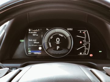 Een digitaal Lexus ES 300h-dashboard met de voertuigsnelheid, brandstofmeter, kilometerteller en diverse andere indicatoren.