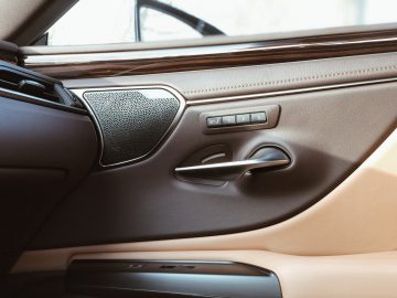 Binnendeurpaneel van een Lexus ES 300h met een luidspreker, raambediening en een deurgreep.