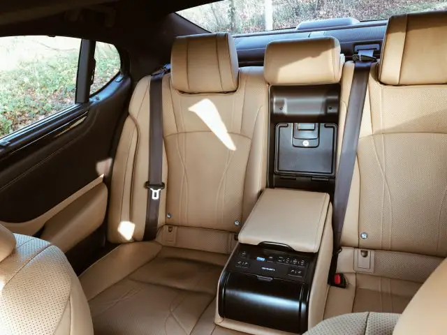 Bruin lederen interieur van de luxe Lexus ES 300h, met de achterbank en de middenarmsteun/console.