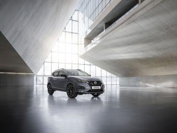 Modern Nissan N-Tec-voertuig tentoongesteld in een minimalistische architectuurruimte van beton en glas.