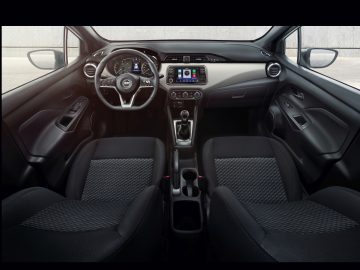 Binnenaanzicht van een Nissan N-Tec-auto met het dashboard, het stuur, het infotainmentsysteem en de voorstoelen.