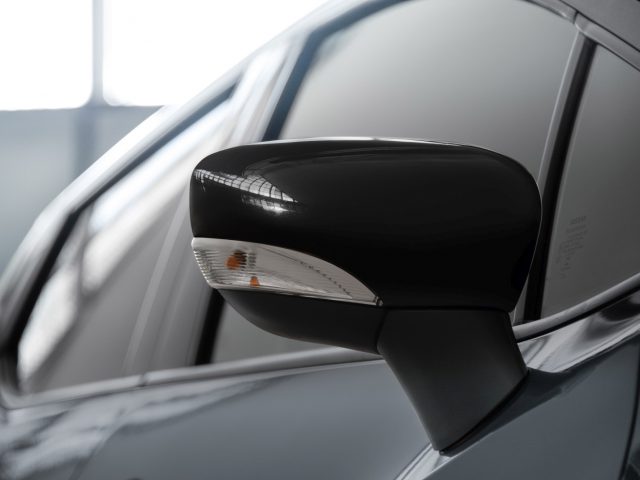 Close-up van de zijspiegel van een Nissan N-Tec-auto met geïntegreerd richtingaanwijzer.