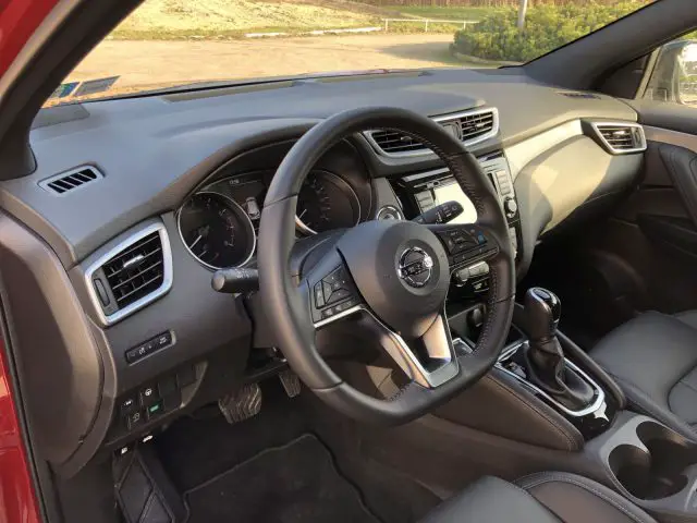 Binnenaanzicht van een Nissan Qashqai met stuur, dashboard en middenconsole.