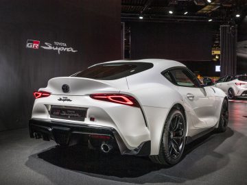 Witte Toyota GR Supra tentoongesteld op een autoshow.