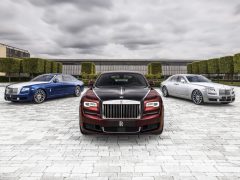 Drie Rolls-Royce-auto's geparkeerd voor een gebouw.