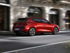 Seat Leon hatchback-auto rijdt door een stadsstraat.
