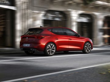 Seat Leon hatchback-auto rijdt door een stadsstraat.