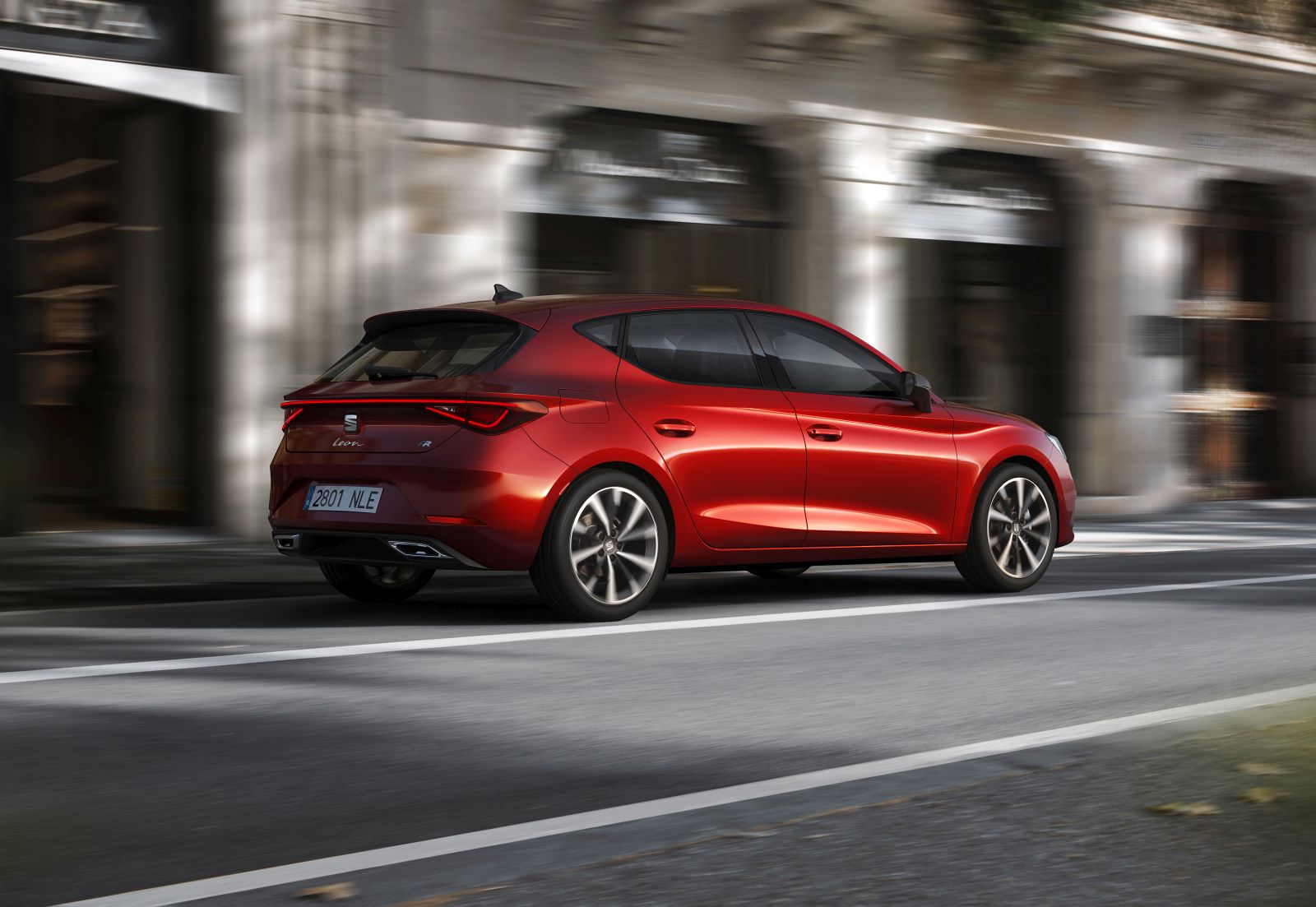 Seat Leon hatchback-auto rijdt door een stadsstraat.