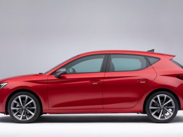 Seat Leon hatchback-auto gepresenteerd in profielweergave tegen een grijze achtergrond.
