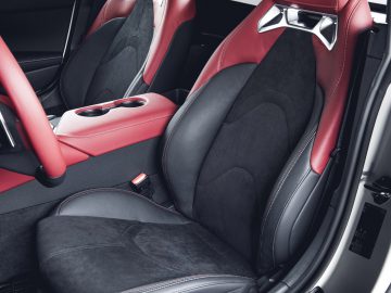 Luxe Toyota Supra-interieur met zwart en rood lederen stoelen met hoogwaardige afwerking.