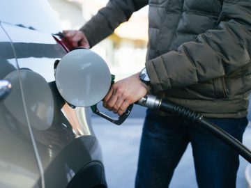 Een man tankt zijn auto met E10-benzine.
