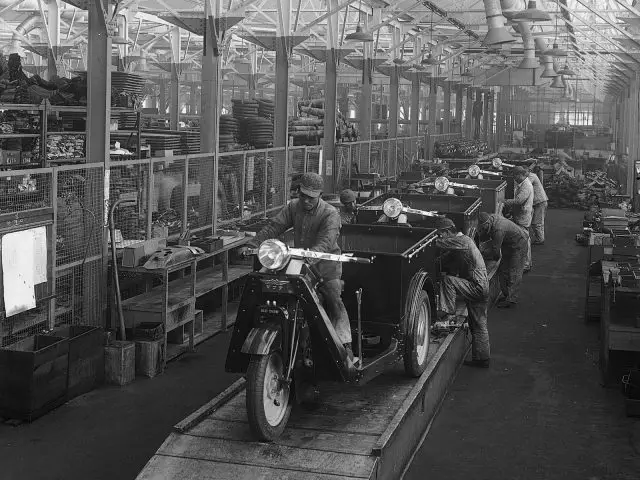 Mannen aan het werk aan een lopende band in een Mazda-fabriek in het begin van de 20e eeuw.