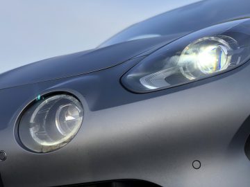 Close-up van de koplamp van een Alpine A110 S-auto met verlichte LED-lampjes.