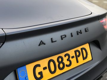 Close-up van de achterkant van een Alpine A110 S-auto met een zichtbare kentekenplaat.