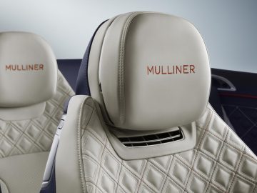 Luxe Bentley Continental GT Mulliner Convertible-interieur met gedetailleerde lederen stiksels en het 'Mulliner'-borduursel op de hoofdsteunen.