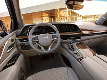 Binnenaanzicht van een Cadillac Escalade met een modern dashboard, lederen stoelen en een touchscreen-infotainmentsysteem.