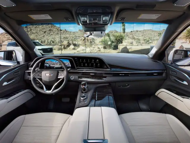 Het luxueuze interieur van een Cadillac Escalade met een digitaal dashboard en lederen stoelen.