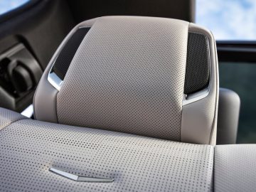 Close-up van een Cadillac Escalade geperforeerd lederen autostoeltje met geïntegreerde hoofdsteun en luidspreker.