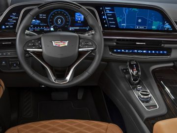 Binnenaanzicht van een Cadillac Escalade met een digitaal dashboard en een met leer bekleed stuurwiel.
