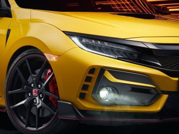 Close-up van een gele Honda Civic Type R Limited Edition, met de koplamp, grille en stuur.