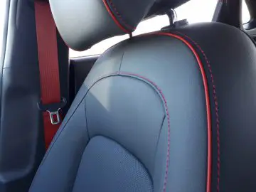 Autostoeltje met rood stiksel en bijpassende rode veiligheidsgordel geschikt voor Kona Hybrid.