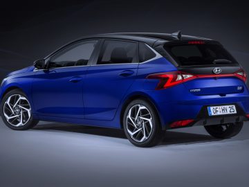 De blauwe Hyundai i20 wordt vanuit een driekwarthoek aan de achterkant getoond.
