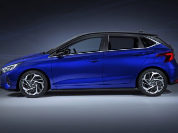 Blauwe Hyundai i20 compacte auto weergegeven op een achtergrond met kleurovergang.