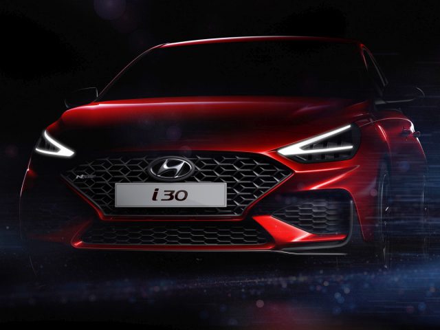 Rode Hyundai i30 tentoongesteld onder dramatische verlichting.