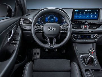 Modern Hyundai i30-interieur met digitaal dashboard, touchscreen-infotainmentsysteem en automatische transmissie.