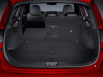 Ruime en lege kofferbak van een moderne rode Hyundai i30 met neergeklapte achterbank.