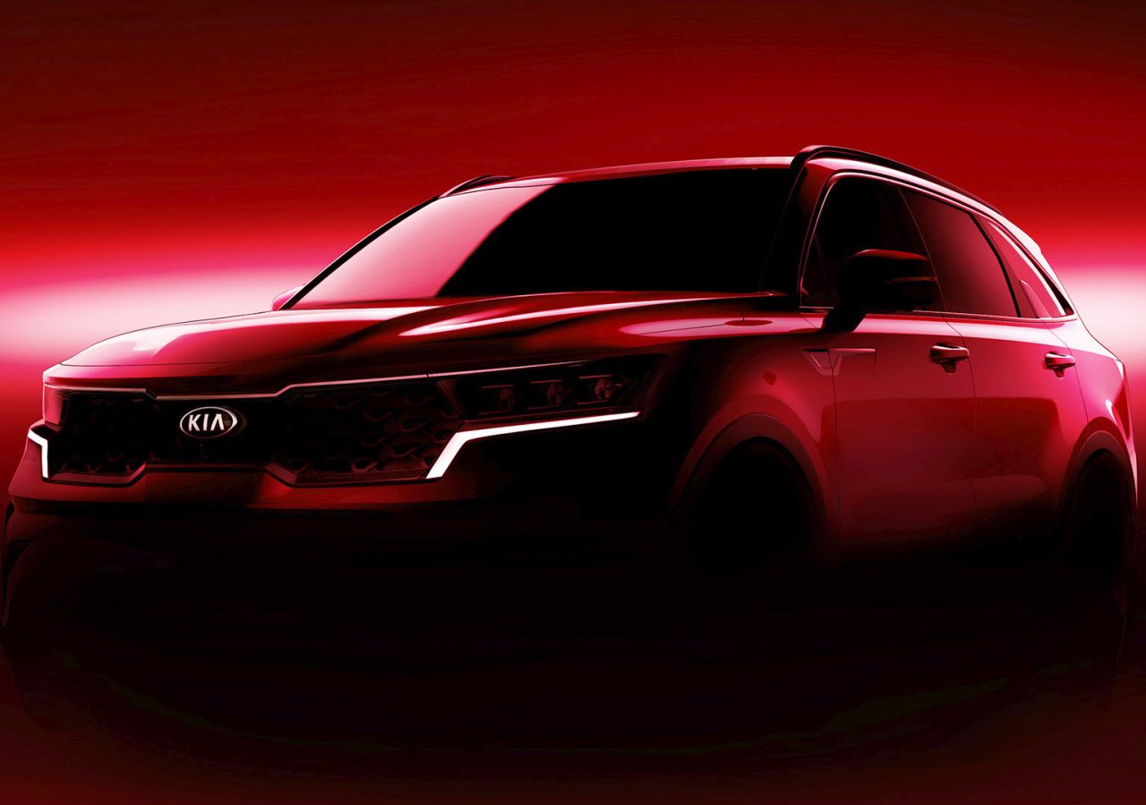 Een rode Kia Sorento-auto met dramatische verlichting tegen een rode achtergrond.