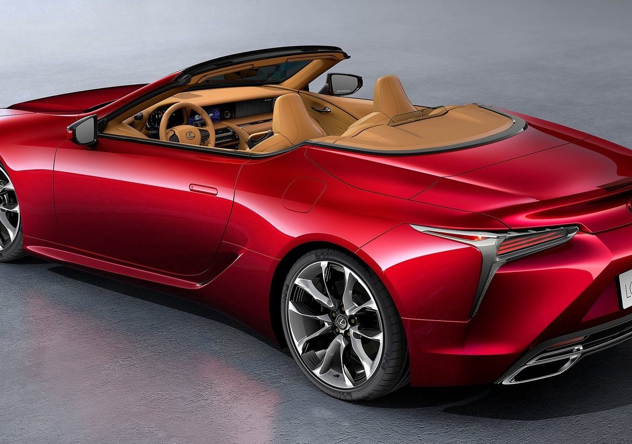 Rode Lexus LC Convertible sportwagen met beige interieur geparkeerd op een grijze vloer.