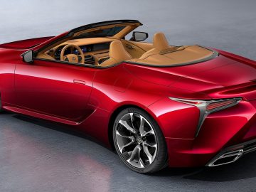 Rode Lexus LC Convertible sportwagen met beige interieur geparkeerd op een grijze vloer.