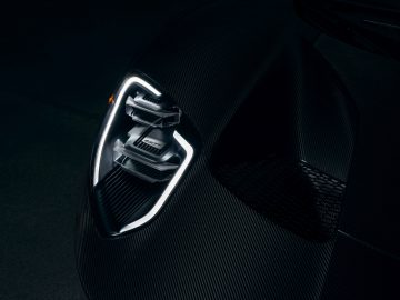Close-up van een gestileerde Ford GT-voertuigkoplamp en koolstofvezelkap.