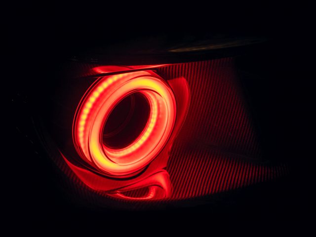 Verlicht rood Ford GT-achterlicht op een donkere achtergrond.