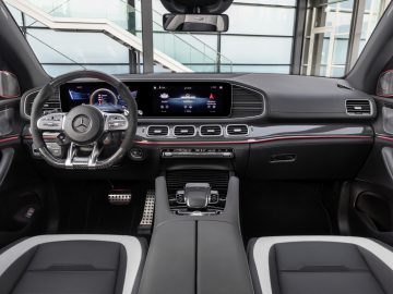 Interieur van een moderne Mercedes-AMG-luxeauto met een digitaal dashboard en infotainmentsysteem.
